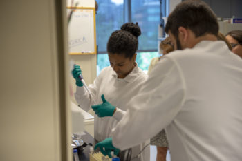 A teacher practices her lab skills with Fred Hutch